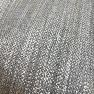 Close-up of metallic woven upholstery fabric in silver, champagne, and gold textured jacquard.